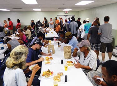 Scores of people enjoy a free meal as part of the People In Need ministry in Virginia Beach, Va.